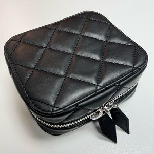 Black quilted cosmetic organizer by Trish McEvoy.